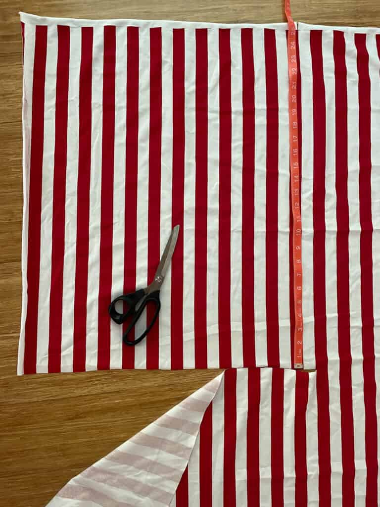 red and white stripe fabric laid out with scissors on top 