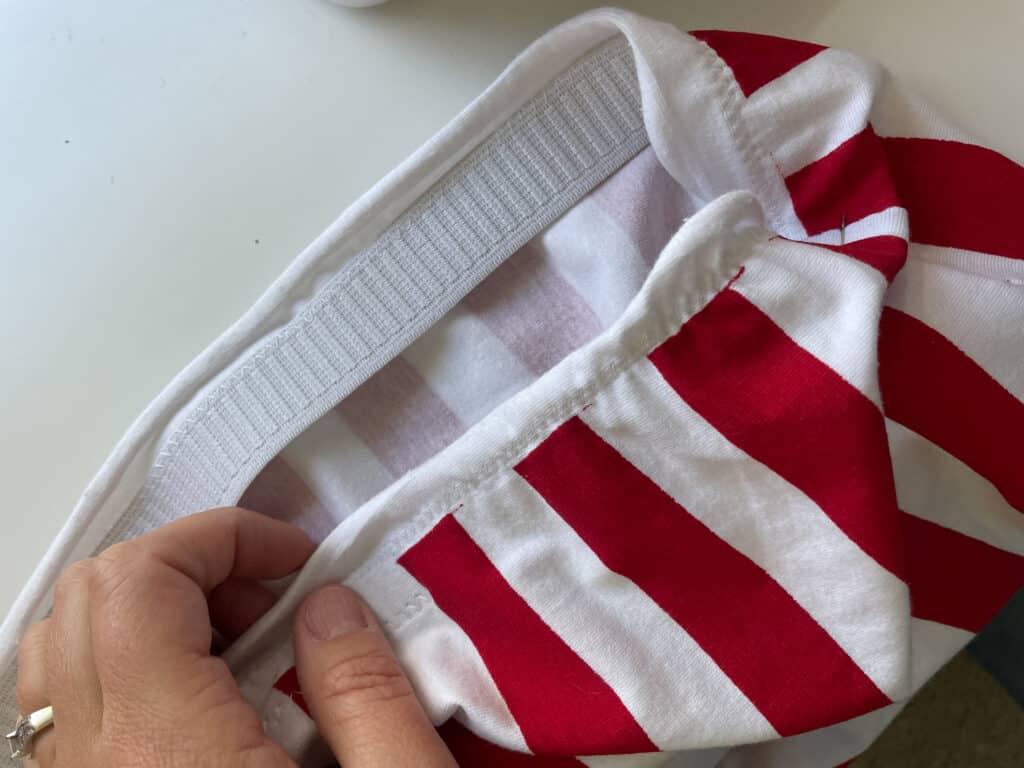 elastic being sewn into a waistband of a red and white pencil skirt
