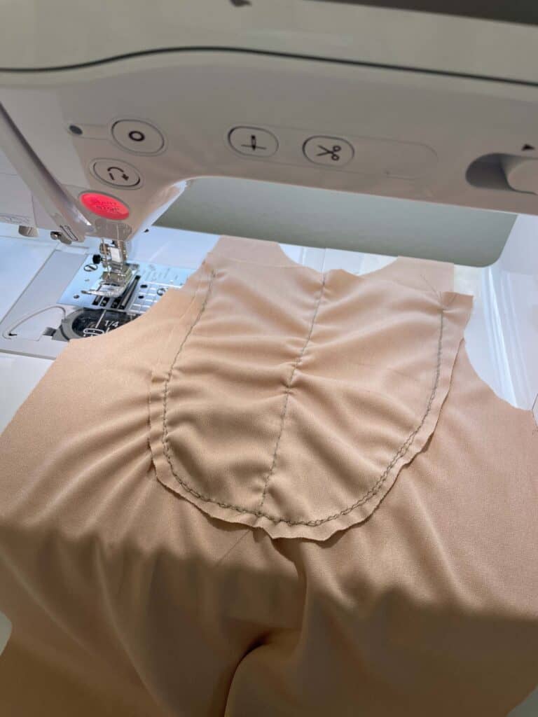Nude fabric on a sewing machine to create muscle pouch 