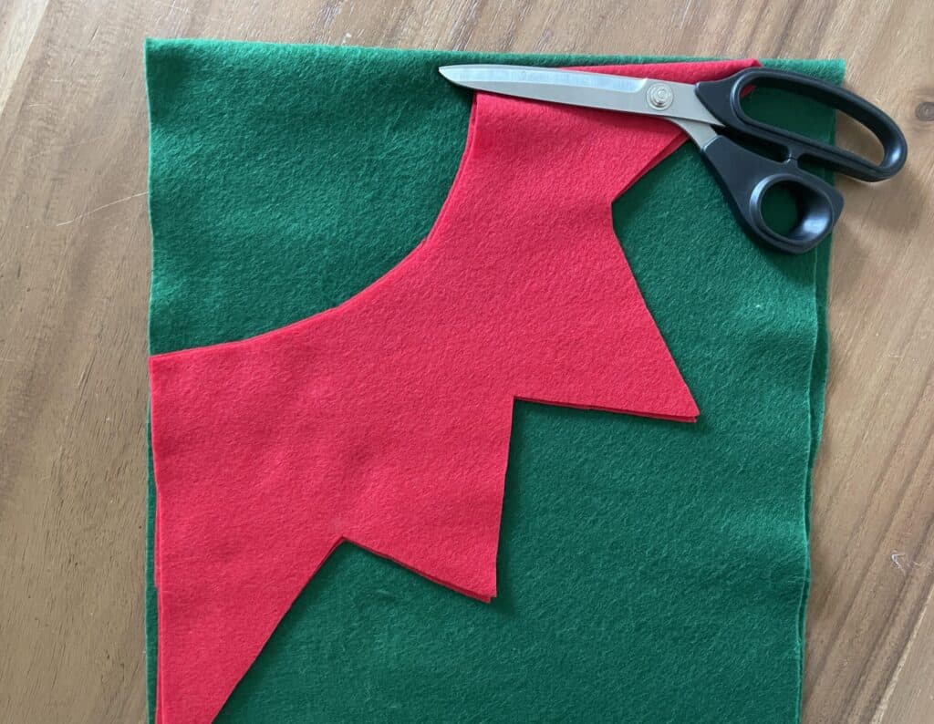 Red felt collar laid on top of green felt waiting to be embellished.